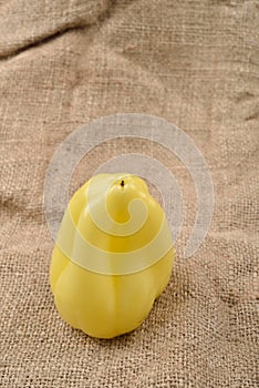 Sweet yellow pepper lying on jute canvas background. Concept of