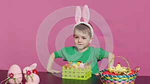 Sweet young boy making colorful arrangements for Easter holiday festivity photo