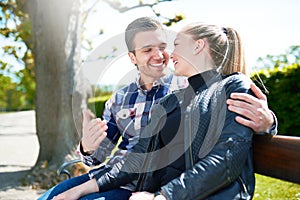 Sweet Young Couple Sitting on Bench at the Park
