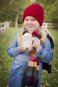 Sweet Young Girl Holding Cocoa Mug with Marsh Mallows Outside