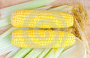 Sweetcorns and cob on wooden table