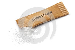 Sweetener powder from a disposable sachet on white background close up