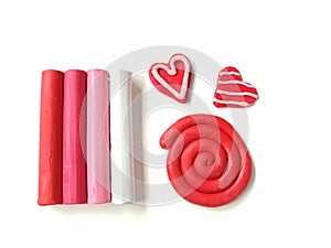 Sweetie colored plasticine, red spiral and couple heart clay dough, white background