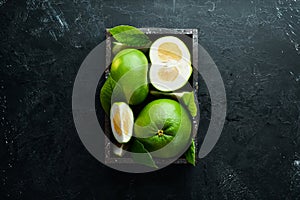 Sweetie green citrus fruit in wooden box.