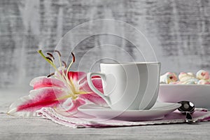 Sweets with coffee and lily flower on table