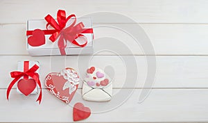 Sweets - gingerbread in the form of hearts and an envelope with gifts for Valentines Day with copy space on a white wooden
