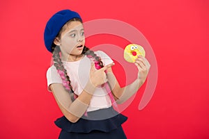 Sweets shop and bakery concept. Kids huge fans of baked donuts. Impossible to resist fresh made donut. Girl hold glazed