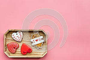 Sweets on Valentine`s Day. Cookies in shape of heart and with lettering I love you on pink background top view copy