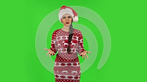 Sweety girl in Santa Claus hat angrily pointing herself, saying who me no thanks i do not need. Green screen