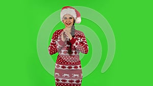 Sweety girl in Santa Claus hat is waiting in anticipation with pleasure. Green screen