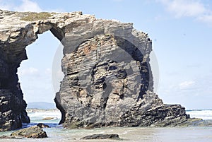 Swell between the big rocks in the blue sea