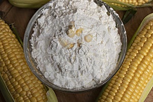 Swigs of raw corn on a burlap napkin and cornstarch in a glass dish. Fresh