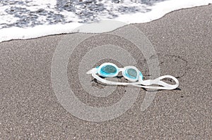 Swim goggles on the sand.