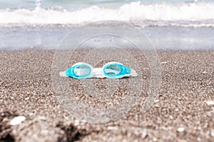 Swim goggles on the sand.