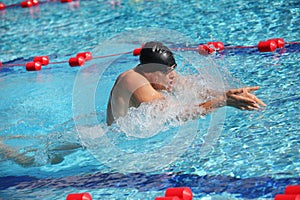 Swimmer in cap breathing performing the breaststroke