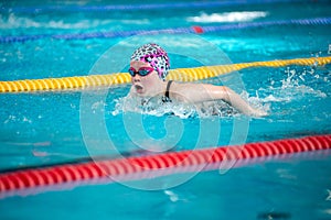 Swimmer girl swims butterfly swimming style in the pool