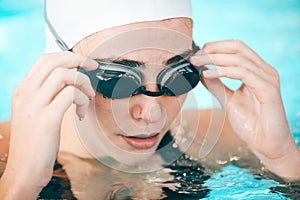 Swimmer, hands and face with goggles in fitness sports for exercise, workout or training in swimming pool. Sporty