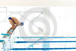 Swimmer jumping from starting block i