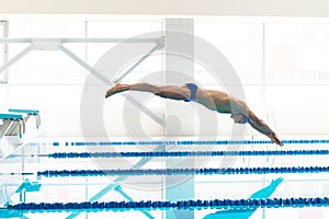 Swimmer jumping from starting block i