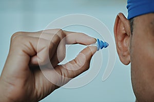 swimmer man about to put an earplug