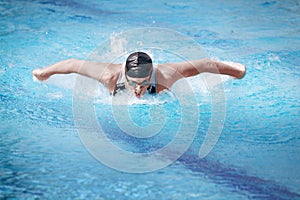 Swimmer performing the butterfly stroke,front