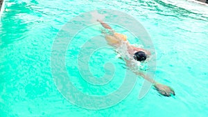 Swimmer. Professional swimmer prepares for competitions in the pool. Young athletic man wearing swimming goggles and mad