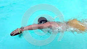 Swimmer. Professional swimmer prepares for competitions in the pool. Young athletic man wearing swimming goggles and mad