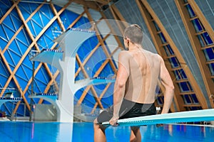 Swimmer sits on a platform for diving