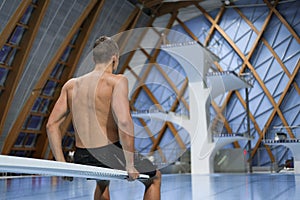 Swimmer sits on a platform for diving