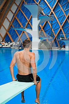 Swimmer sits on a platform for diving