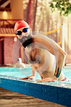 swimmer standing on diving board ready to jump into competition swimming pool