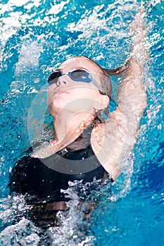 Swimmer in swim meet doing backstroke