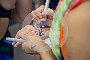 Swimmer writing events and heats on fellow swimmer