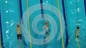 Swimmers compete in the pool of three men