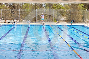 Swimmers while jumping in the swimming pool in a competition