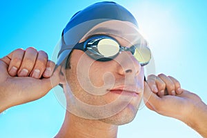 Swimming cap, goggles and sports man ready for exercise, outdoor workout or training for summer contest. Swimwear, blue