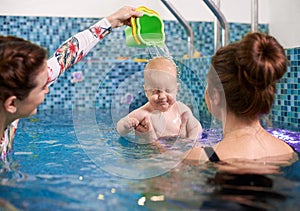 Swimming classes for little ones, infant with mother in swimming pool during training