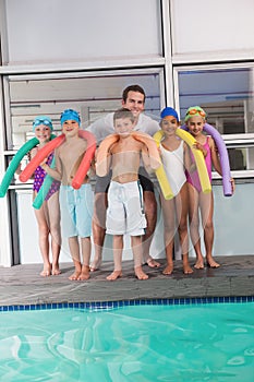 Swimming coach with his students poolside