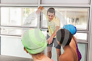 Swimming coach with his students poolside