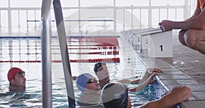 Swimming coach talking to swimmers