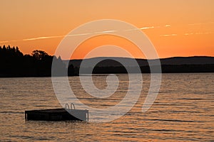 Swimming float and lake in Vermont at sunset