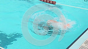 Swimming. The girl athlete swims in a crawl and makes a turn in the pool.