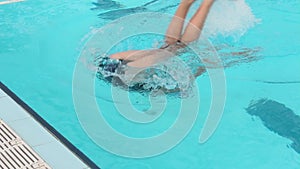 Swimming. The girl athlete swims in a crawl and makes a turn in the pool.