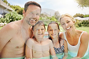 Swimming is an important life skill. Shot of a couple and their two children spending time by the pool.