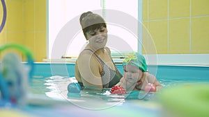 Swimming Instructor with Cute Baby in the Pool