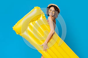 Swimming Joy. Positive african girl with yellow inflatable mattress over blue background