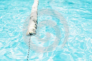 Swimming lanes with clear blue water in public swimming pool in summer