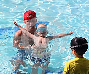 Swimming lesson with little boy and watcher