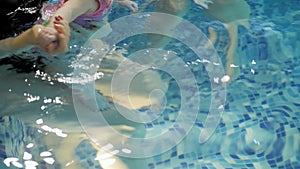 Swimming lesson. Mothers teaching to swim newborn baby at swimming pool