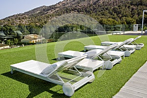 Swimming pool area with white sun beds at the modern resort.